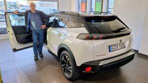 SOLIX ENERGIE-Vorstand Harald Dettmer in der Tür des 7. Fahrzeugs von SOLIX MOBIL, einem Peugeot